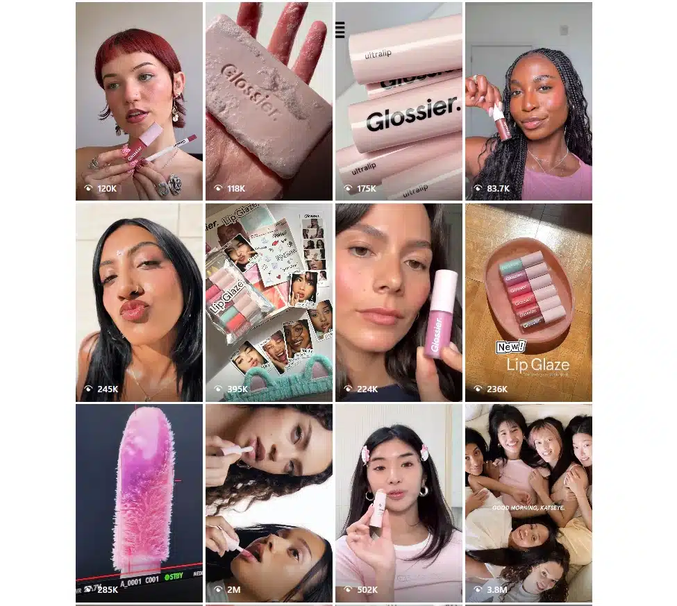 A grid of Glossier Instagram Reels featuring various creators using and displaying Glossier lip products. The grid shows diverse individuals, lip gloss packaging, and product close-ups, with views ranging from 83K to 3.8M.