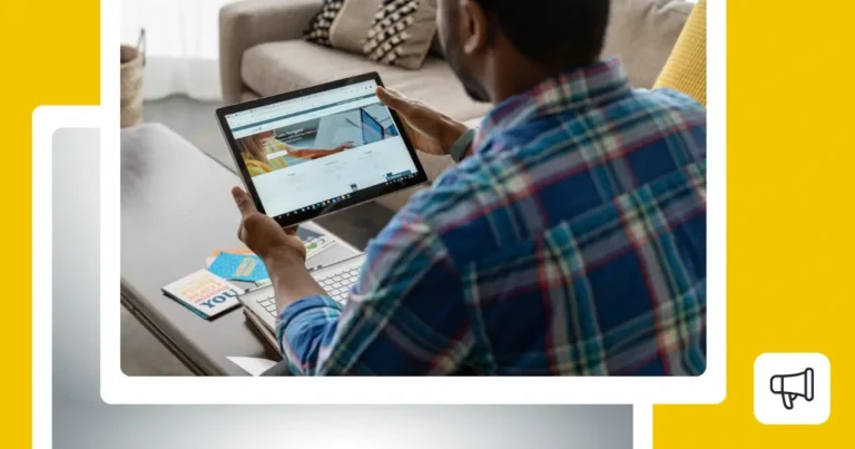Person in a blue plaid shirt holding a tablet displaying a LinkedIn page.