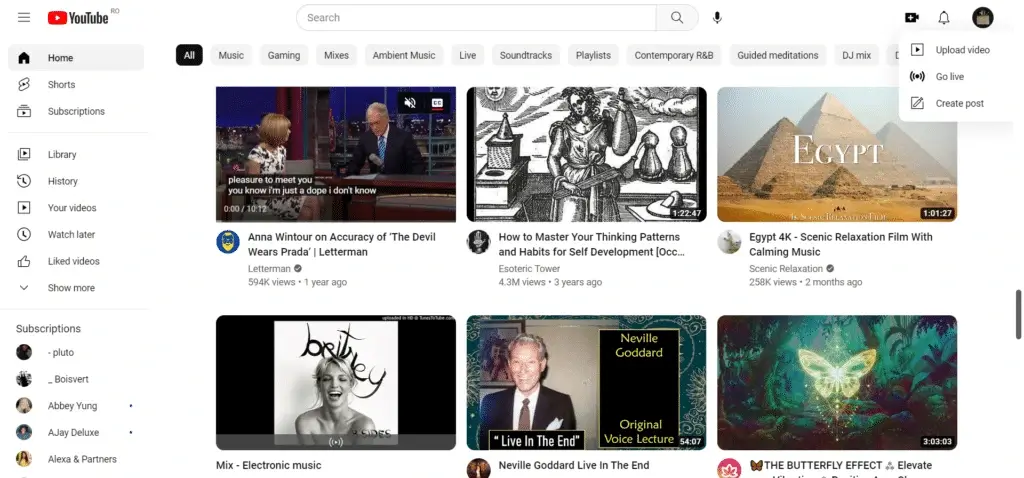 YouTube homepage with the user menu expanded in the top-right corner, showing the option to create a post, go live, or upload a video.