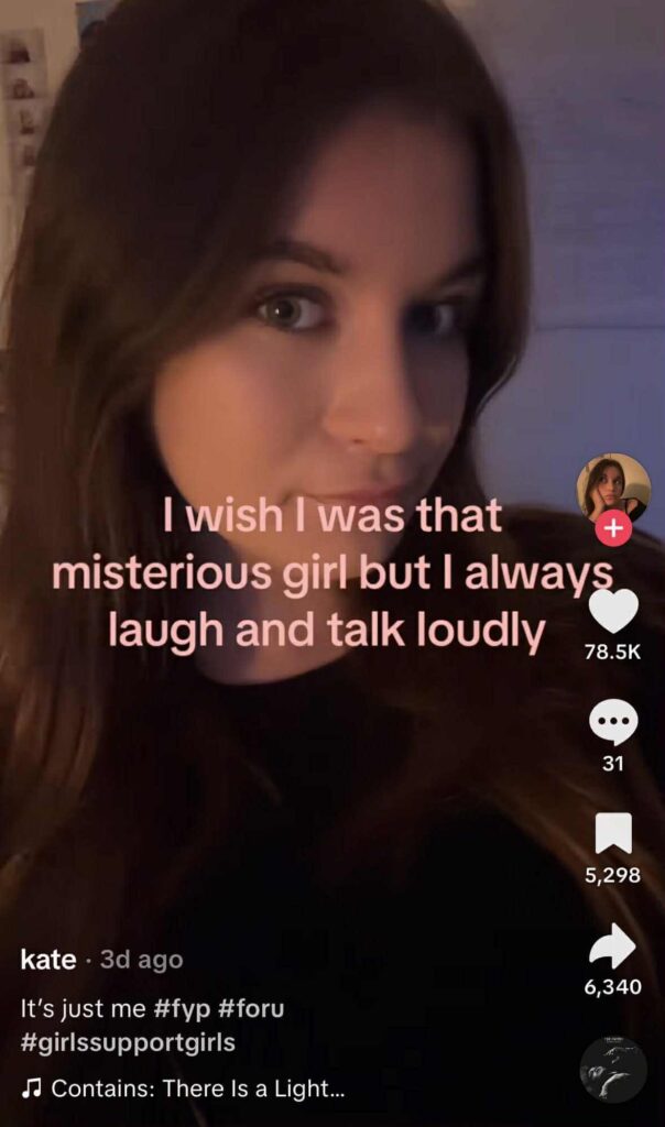 A woman takes a selfie-style video with soft lighting and text overlay that reads, “I wish I was that mysterious girl but I always laugh and talk loudly."