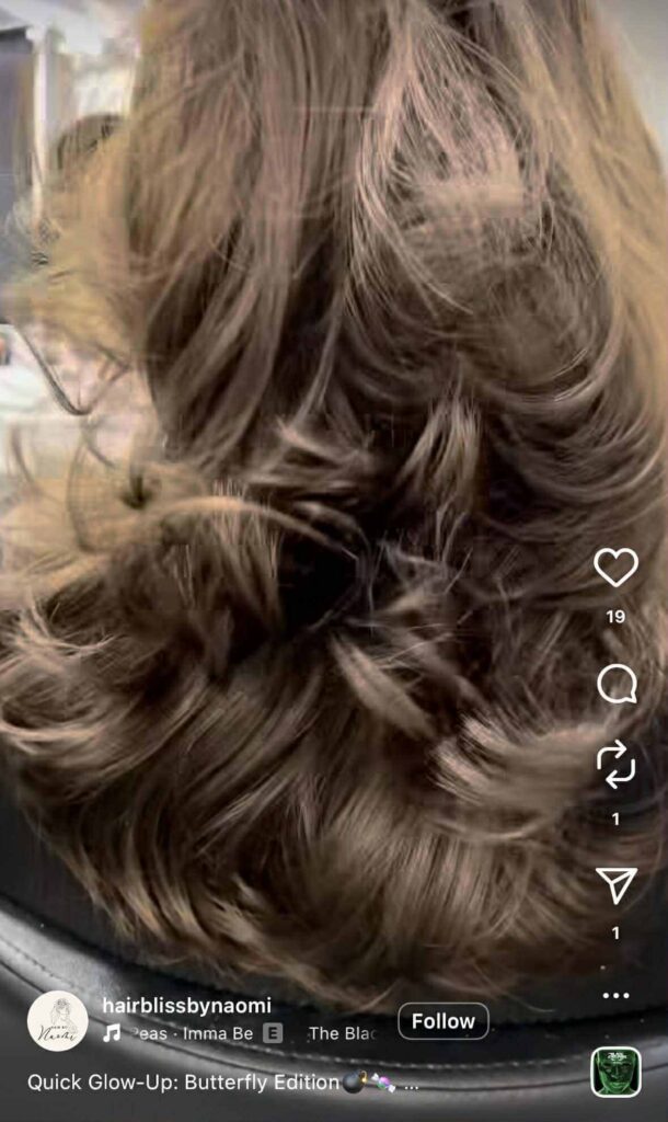 Instagram Reel showing the back view of freshly styled, voluminous brown hair with soft, bouncy curls.