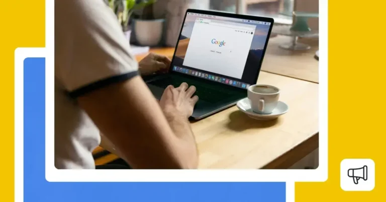Person using a laptop with Google homepage open, seated at a wooden table with a cup of coffee, representing online search, Google tools, or digital marketing activities.