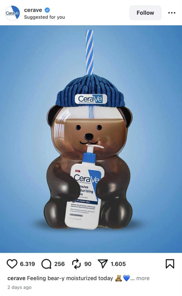 A bear bottle wearing a blue CeraVe beanie and holding a CeraVe moisturizing lotion bottle, with a blue-striped straw coming out of the hat.