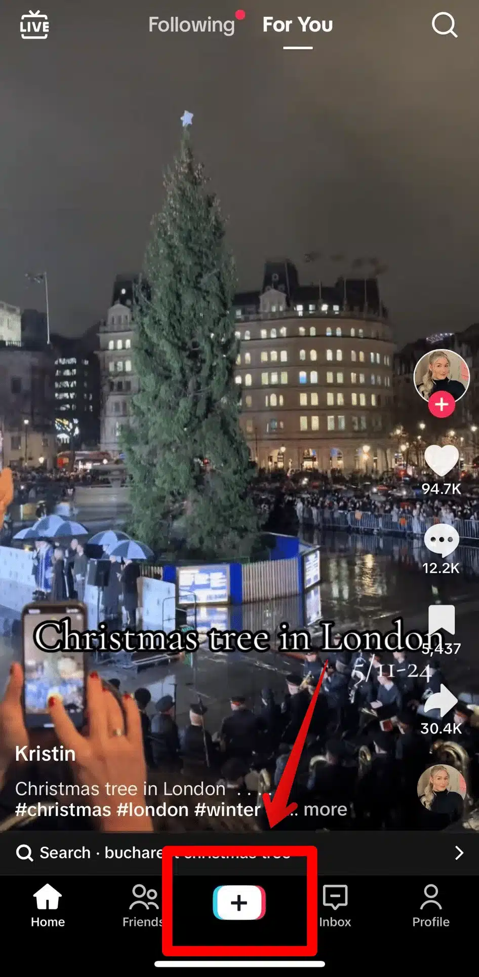 TikTok interface showing a Christmas tree in London on the "For You" page, with a red arrow pointing to the center "+" button used to create a new post.