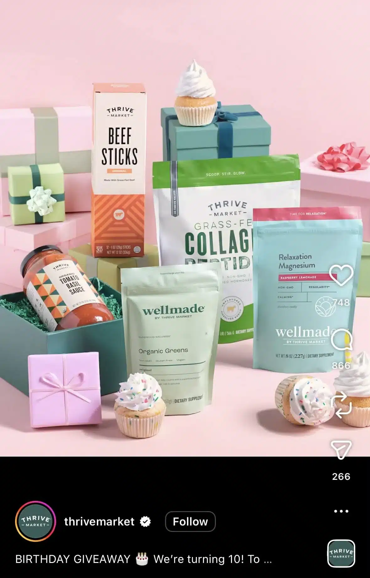 Flat lay of Thrive Market birthday giveaway featuring collagen peptides, organic greens, tomato basil sauce, beef sticks, and magnesium supplements, surrounded by pastel gift boxes and cupcakes on a pink background.