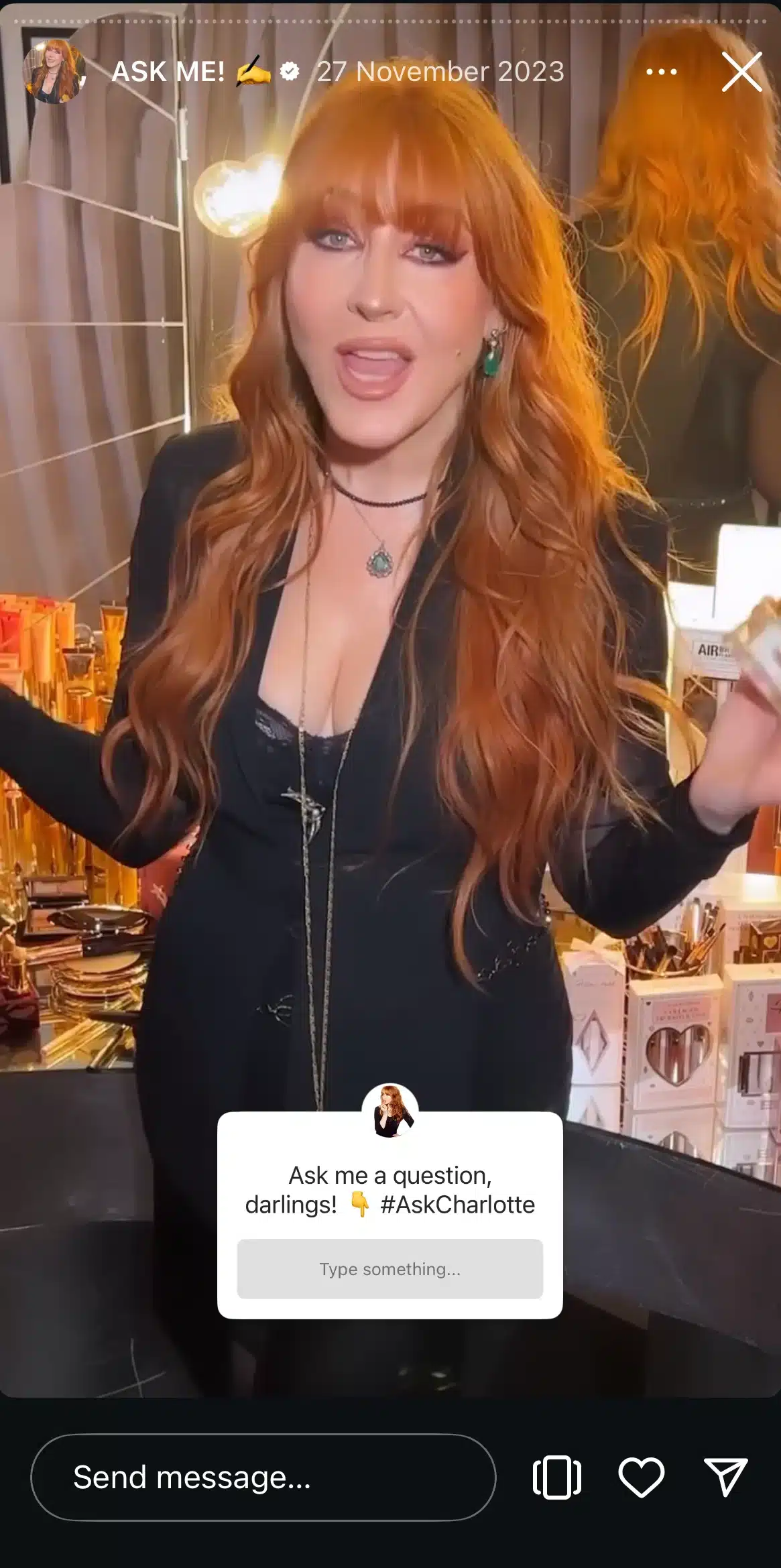 Charlotte Tilbury speaking in a makeup studio filled with beauty products, inviting viewers to submit questions through an Instagram Q&A sticker.