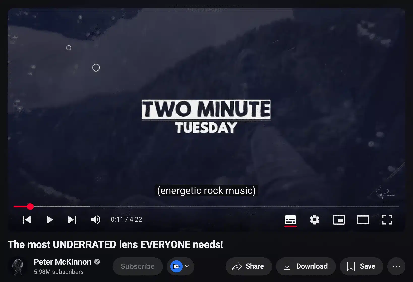 YouTube video screenshot from Peter McKinnon's channel showing the intro screen with bold text 'TWO MINUTE TUESDAY' over a dark, mountainous background. The subtitle at the bottom reads '(energetic rock music).