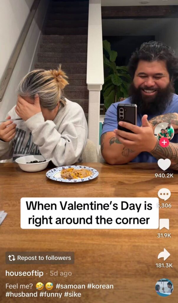 Couple sitting at a table eating; the woman covers her face while the man laughs and films on his phone, with on-screen text about Valentine’s Day being right around the corner.