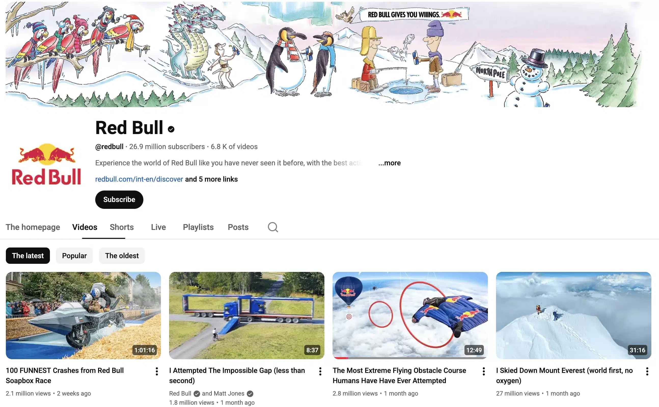 Screenshot of the Red Bull YouTube channel homepage showing a winter-themed illustrated banner, the verified @redbull profile with 26.9 million subscribers, and a grid of extreme sports videos including wingsuit flying, skiing, and the Red Bull Soapbox Race, highlighting Red Bull’s action sports and adventure content on YouTube.