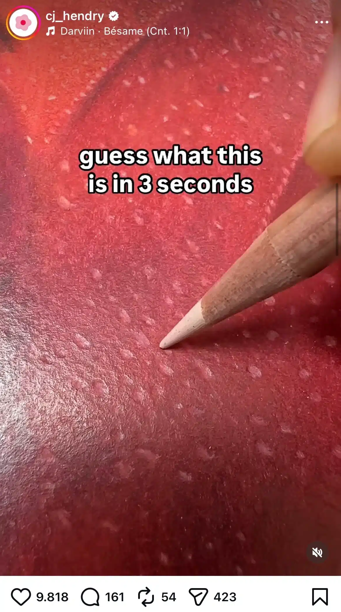 Instagram post by @cj_hendry featuring a hyperrealistic colored pencil drawing in progress, showing the tip of a pencil shading a detailed red strawberry surface with visible seeds and textured highlights, overlaid with the text “guess what this is in 3 seconds.”