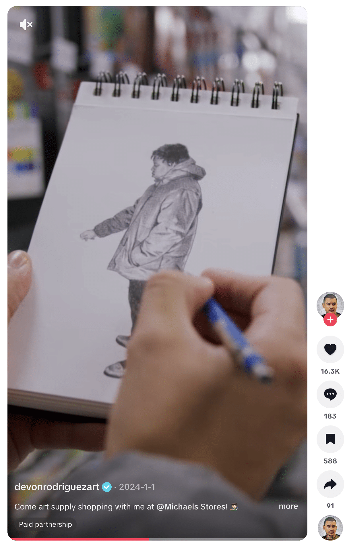 Close-up of hands holding a spiral-bound sketchbook while drawing a realistic pencil sketch of a person wearing a jacket. The image appears within the TikTok interface, showing engagement icons, the creator’s username, and a caption about shopping for art supplies at Michaels as part of a paid partnership.