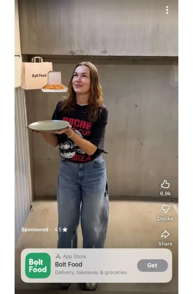 YouTube Shorts sponsored ad for Bolt Food showing a woman holding a plate while a pizza box and delivery bag float beside her, with app download prompt and “Get” button.