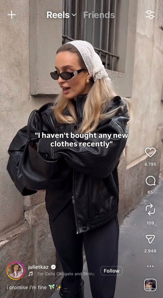 Woman wearing a black leather jacket and sunglasses on a street with text overlay “I haven’t bought any new clothes recently” in an Instagram Reel