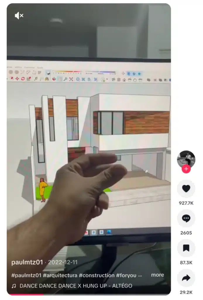 TikTok video showing a hand pointing at a 3D architectural rendering of a modern house displayed on a computer monitor.