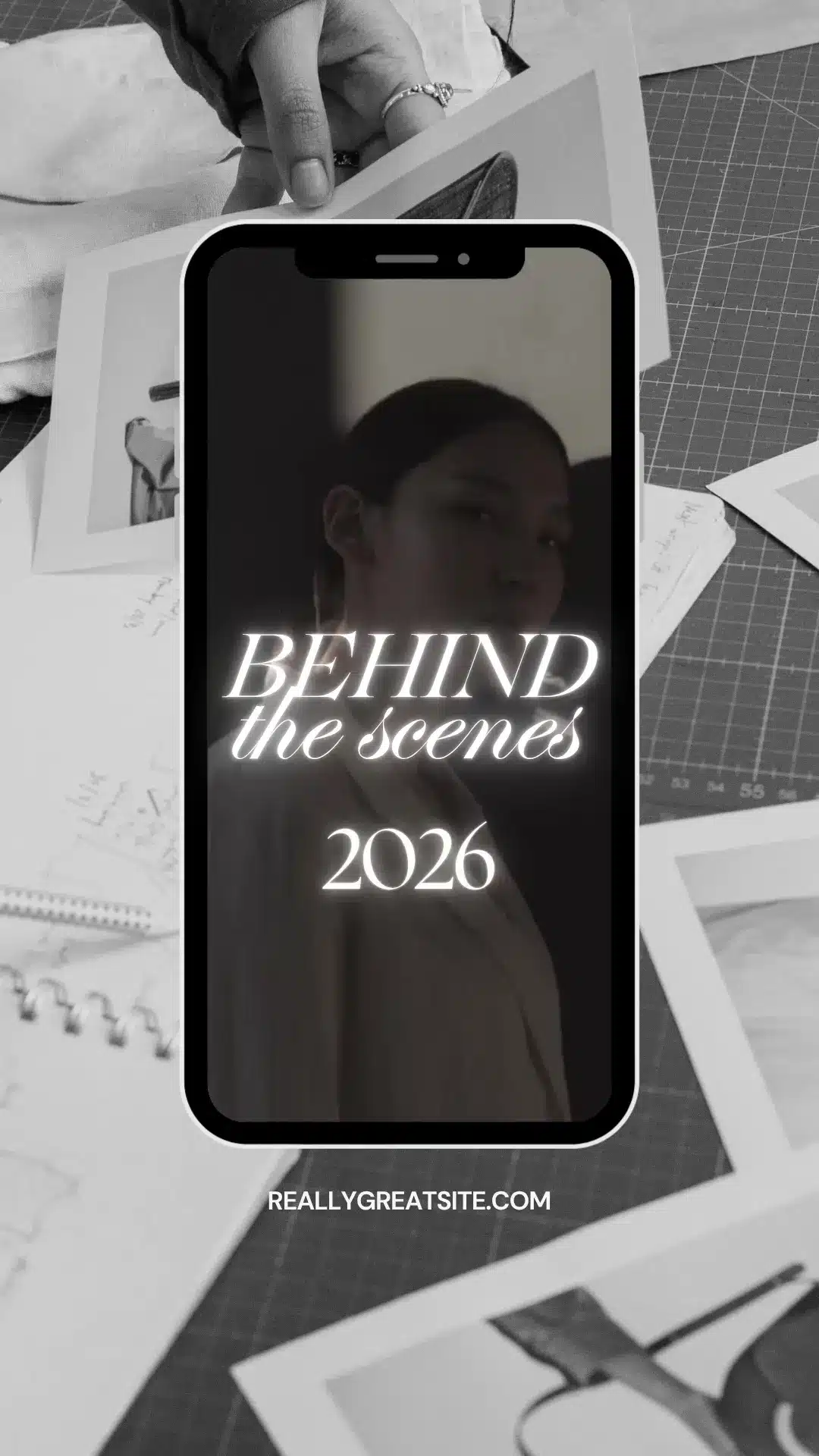 Una ilustración promocional en blanco y negro que muestra el marco de un smartphone situado en el centro de un escritorio lleno de bocetos, fotos y material de diseño. Dentro del marco del móvil hay un retrato de una mujer con un texto que brilla y dice «BEHIND the scenes 2026».