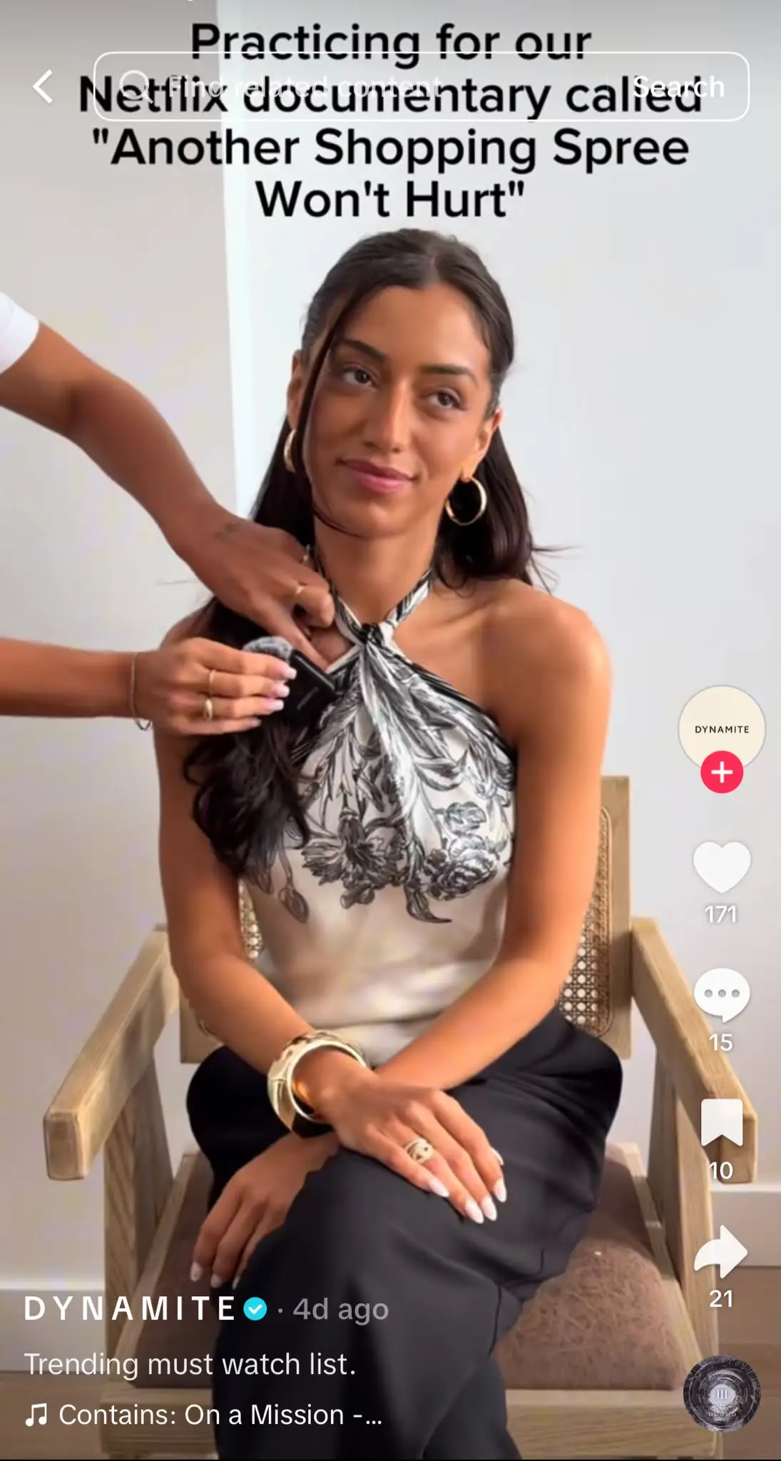 Instagram Reel showing a woman sitting in a chair while someone clips a microphone to her outfit. The on-screen text reads, "Practicing for our Netflix documentary called 'Another Shopping Spree Won't Hurt,'", using the Netflix documentary trend to joke about excessive shopping habits.