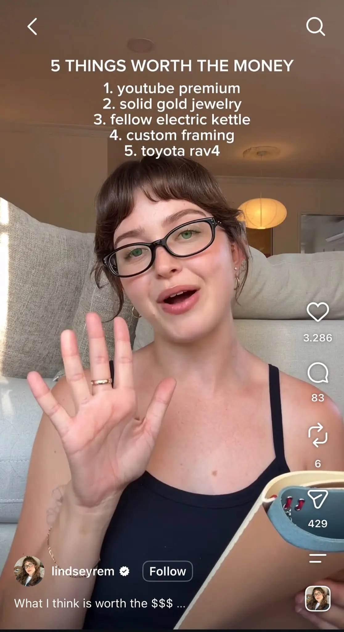 Instagram Reel featuring a creator speaking to the camera while holding up five fingers. Large text at the top reads "5 THINGS WORTH THE MONEY" followed by a numbered list: 1. YouTube Premium, 2. Solid gold jewelry, 3. Fellow electric kettle, 4. Custom framing, 5. Toyota RAV4. The standard Reels interface appears on the right with like, comment, share, and save icons, while the creator's username, follow button, and caption are shown at the bottom.