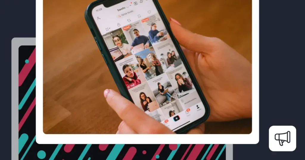 A person holding a smartphone displaying the TikTok app, with a grid of videos visible on the screen while scrolling through a brand's TikTok profile.