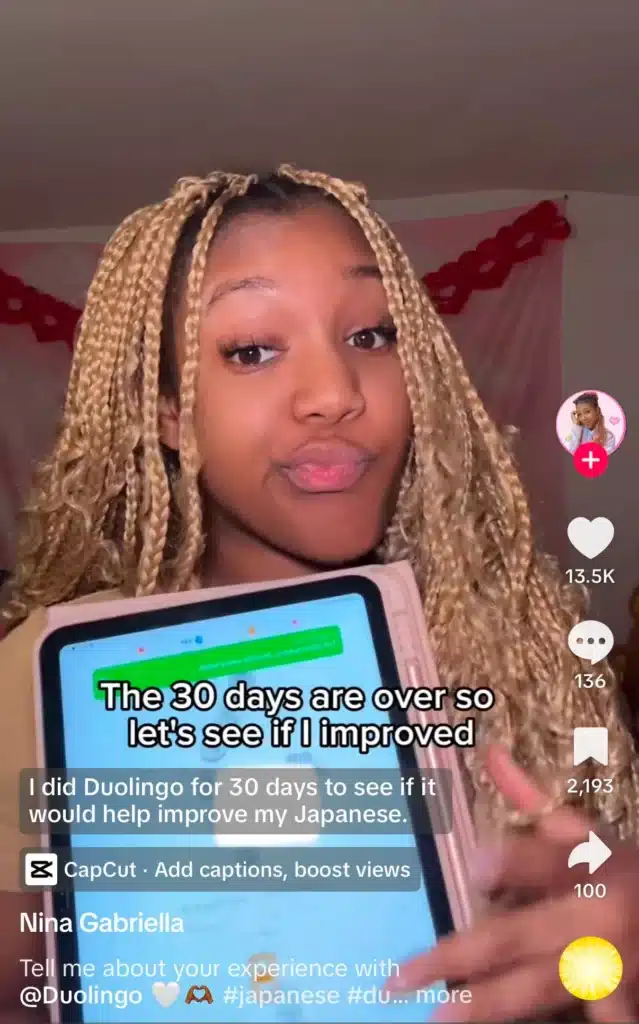 TikTok creator sharing results after completing a 30-day Duolingo Japanese learning challenge while holding a tablet.