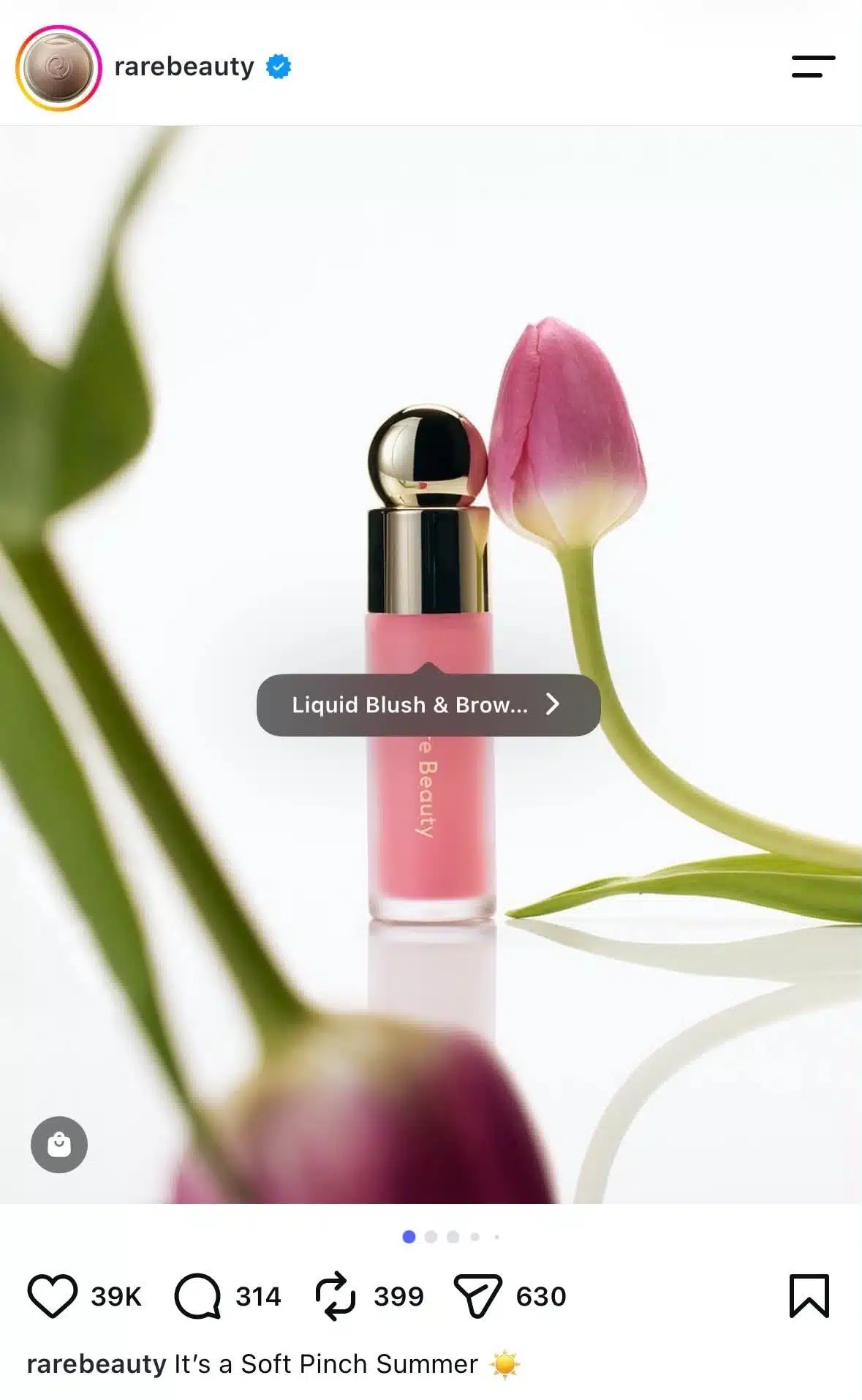 Instagram carousel post from the verified Rare Beauty account featuring a liquid blush beside a pink tulip. A product tag overlay appears on the image, allowing users to tap and view product details directly from the post.