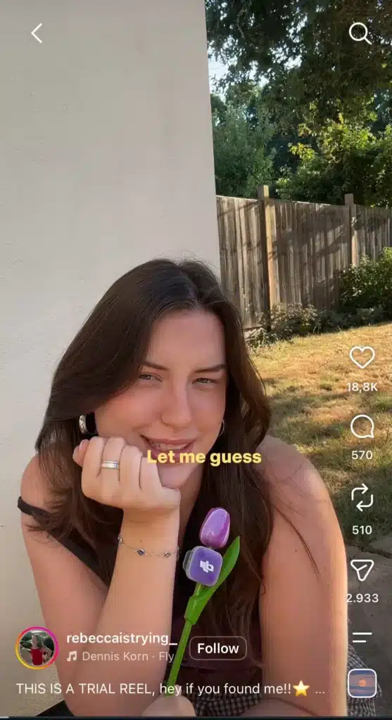 Instagram Reel showing a woman holding a purple tulip outdoors, with yellow on-screen text reading “Let me guess,” as part of the “Let Me Guess” social media trend.