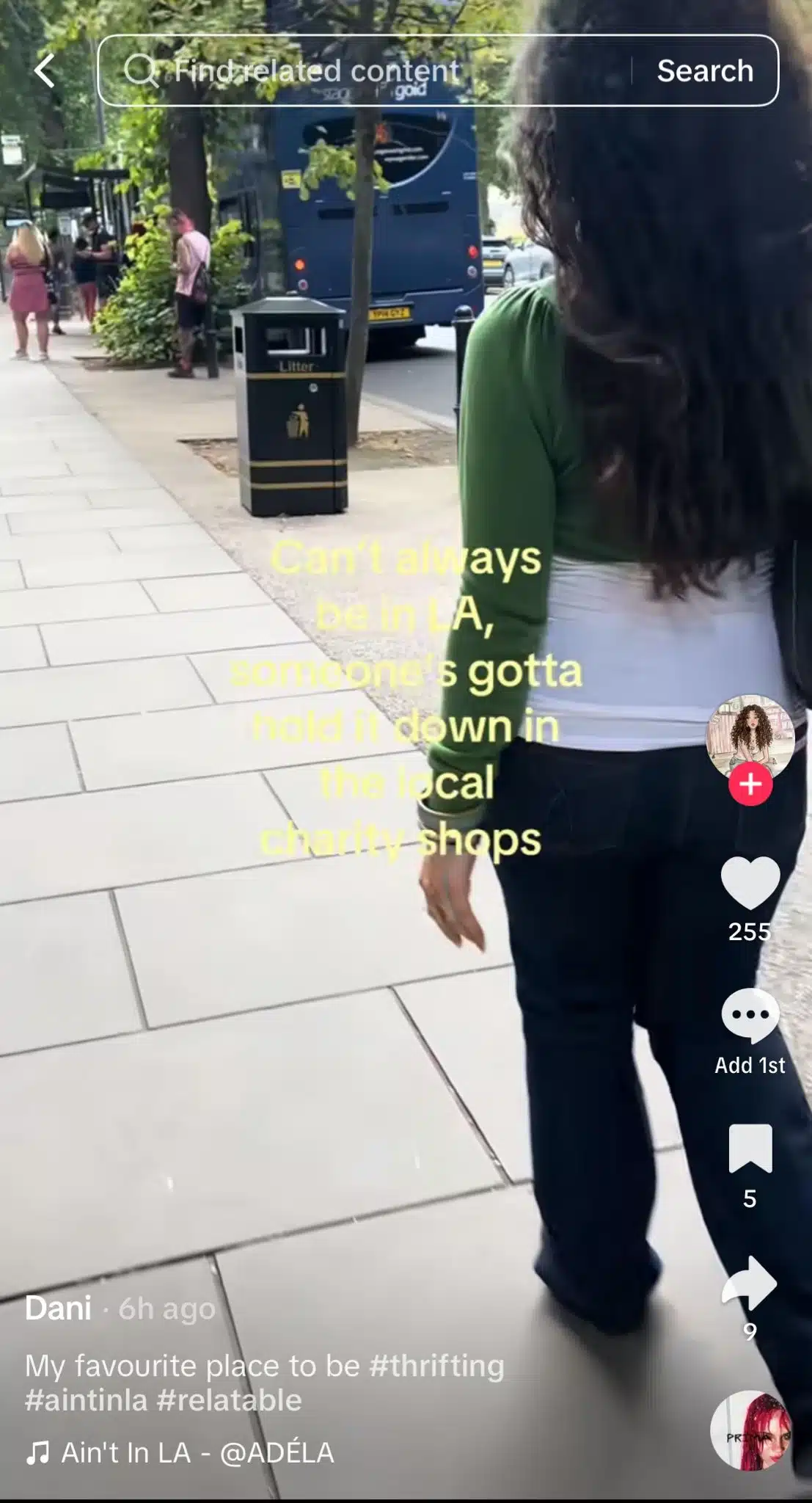 TikTok video showing a woman walking down a city sidewalk with text reading, “Can’t always be in LA, someone’s gotta hold it down in the local charity shops.”
