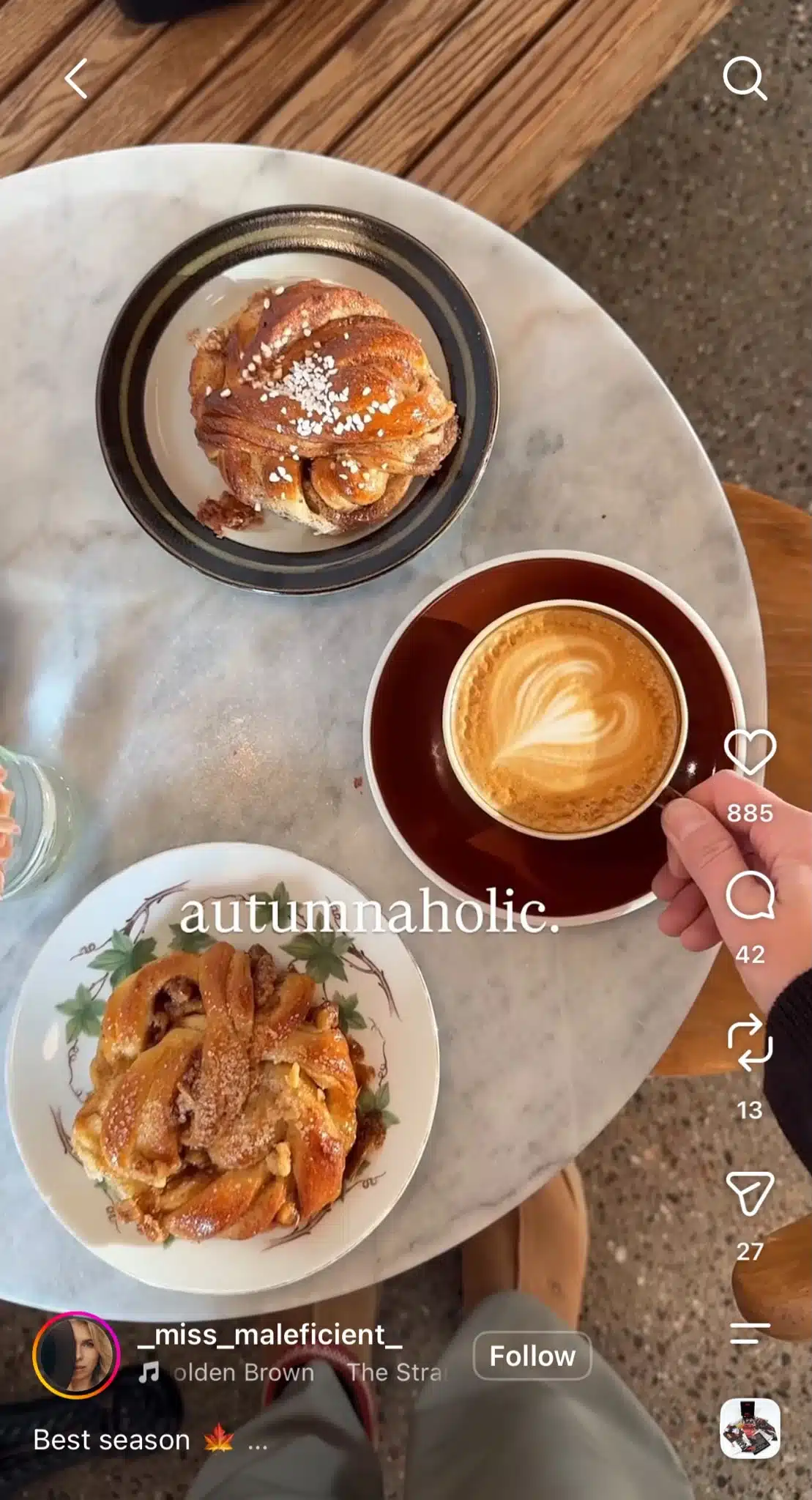 Instagram Reel showing coffee and pastries on a café table with the word “autumnaholic” overlaid across the scene.