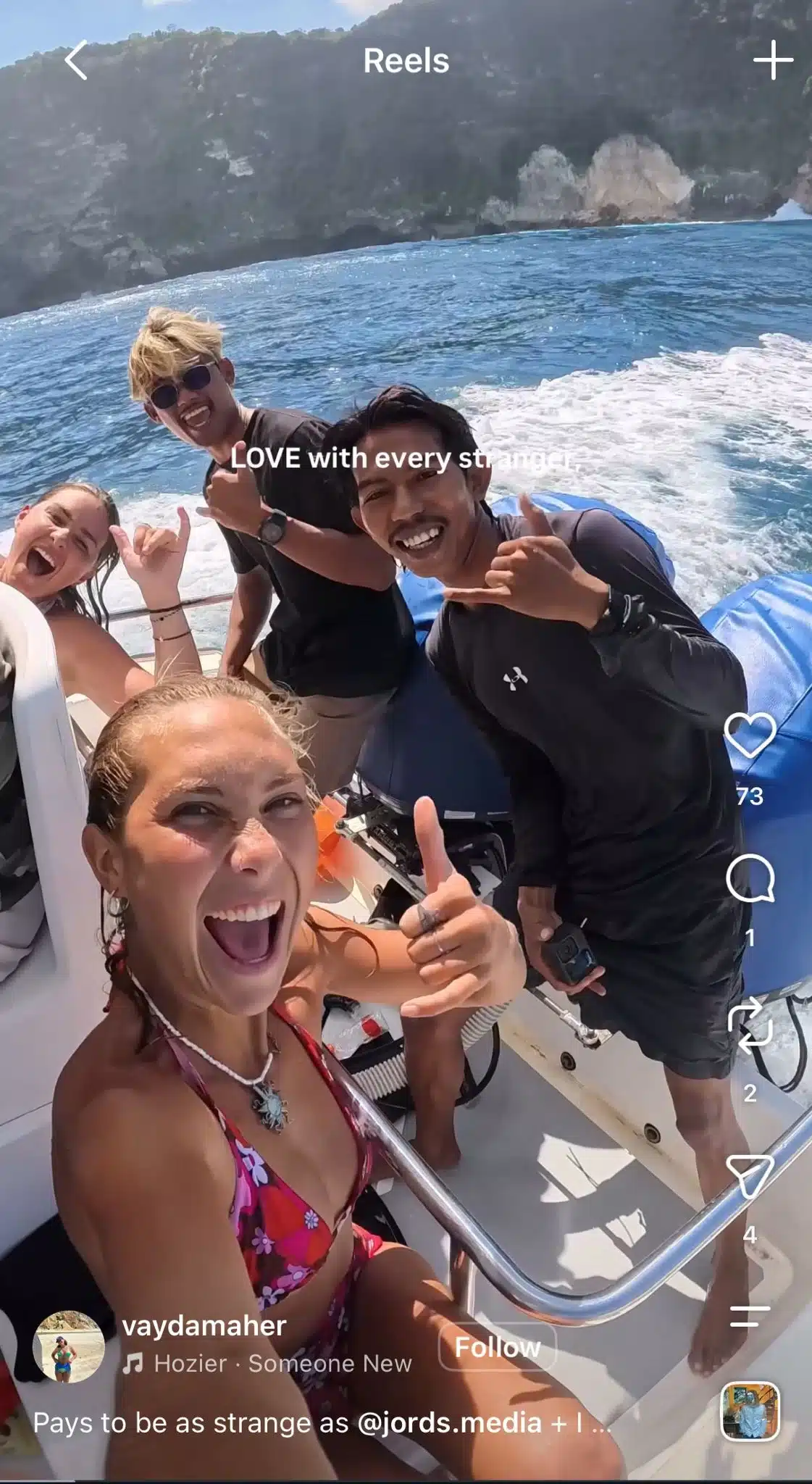 Instagram Reel showing a group of friends smiling on a boat by a rocky coastline, with text reading “Love with every stranger” and Hozier’s “Someone New” as the audio.