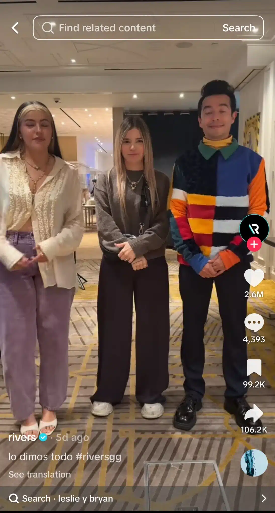 TikTok video featuring three creators standing together indoors, set to a song by Karol G.