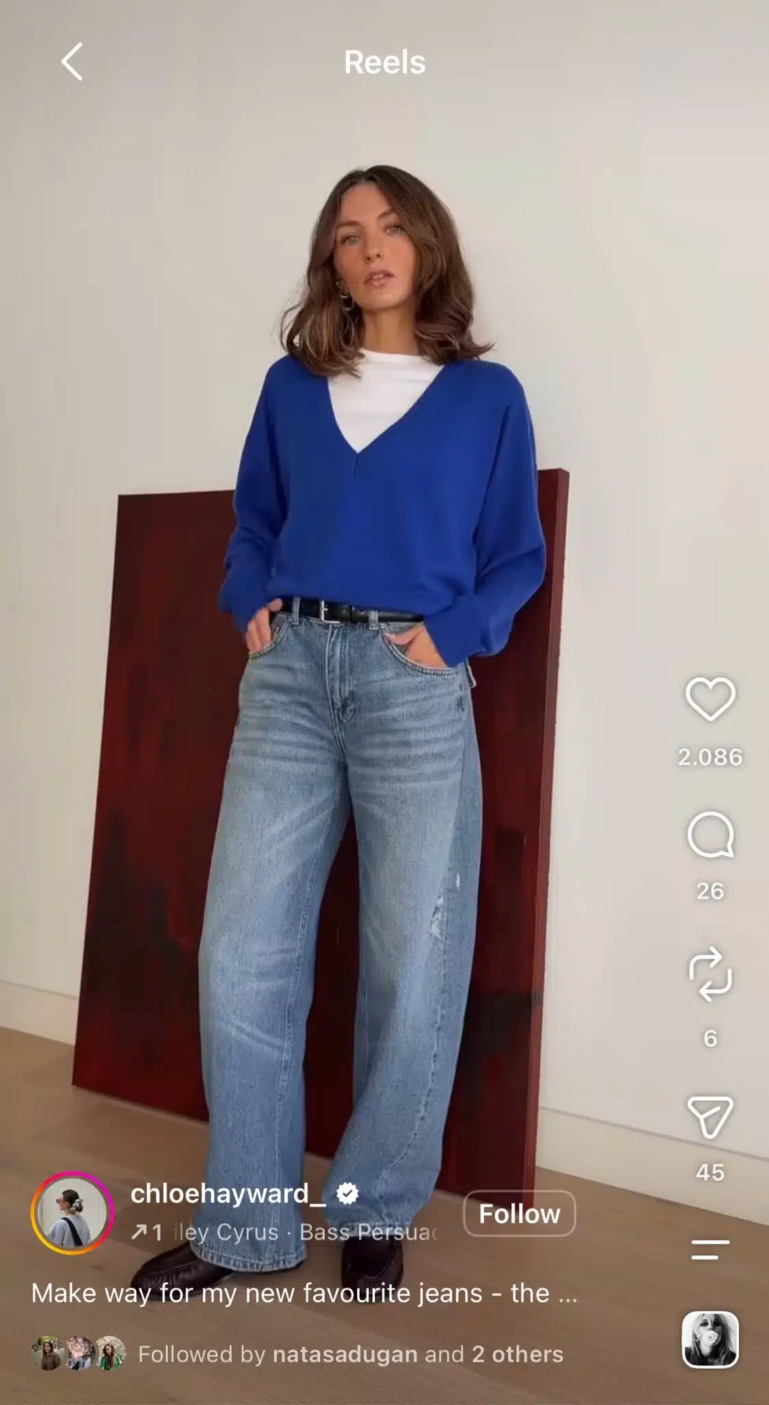 Instagram Reel featuring a fashion creator modeling a blue sweater and wide-leg jeans, set to Miley Cyrus’s “Bass Persuasion.”