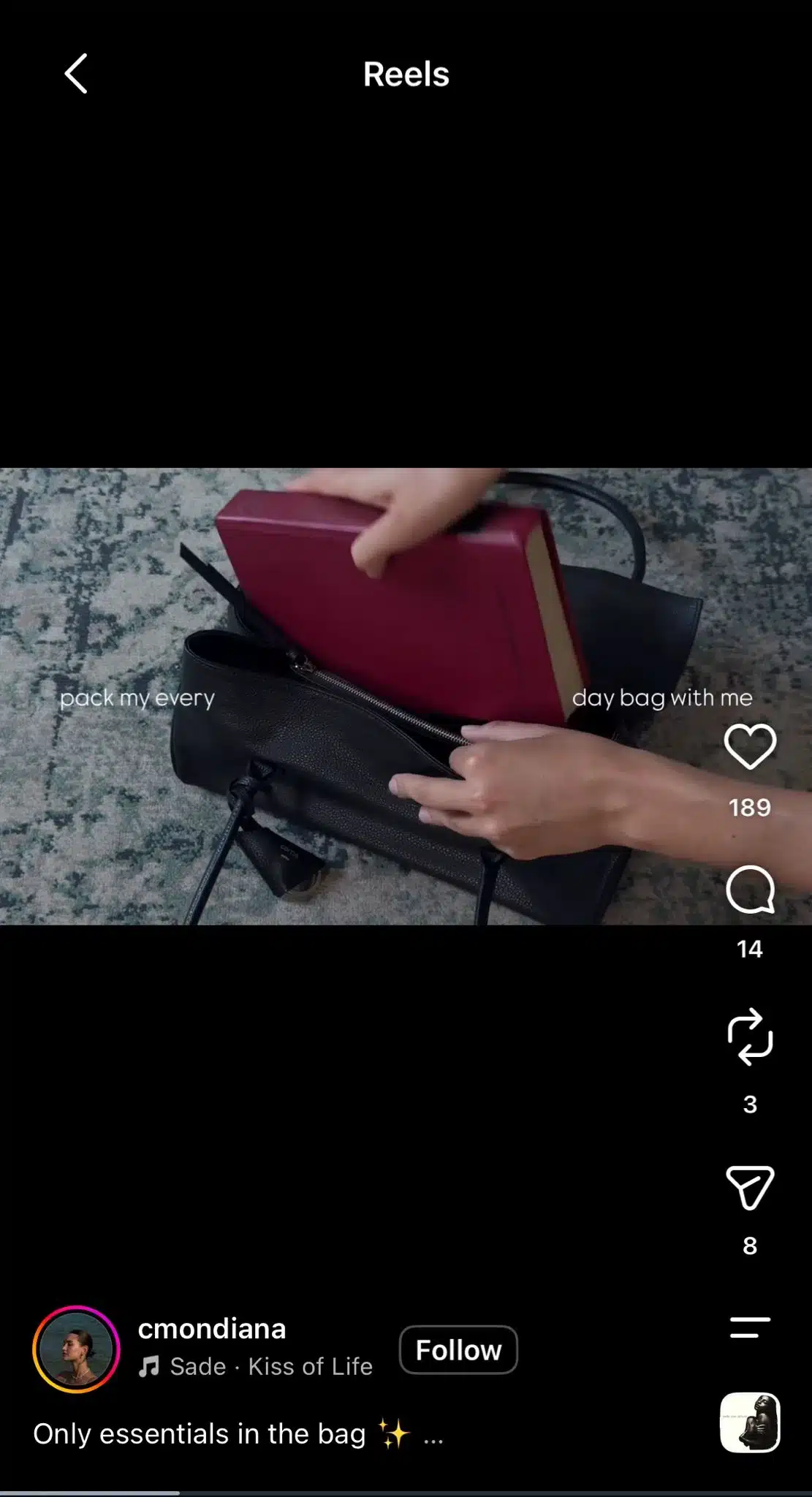 Instagram Reel showing someone packing a red book into a black handbag, with text reading “pack my every day bag with me” and Sade’s “Kiss of Life” as the audio.