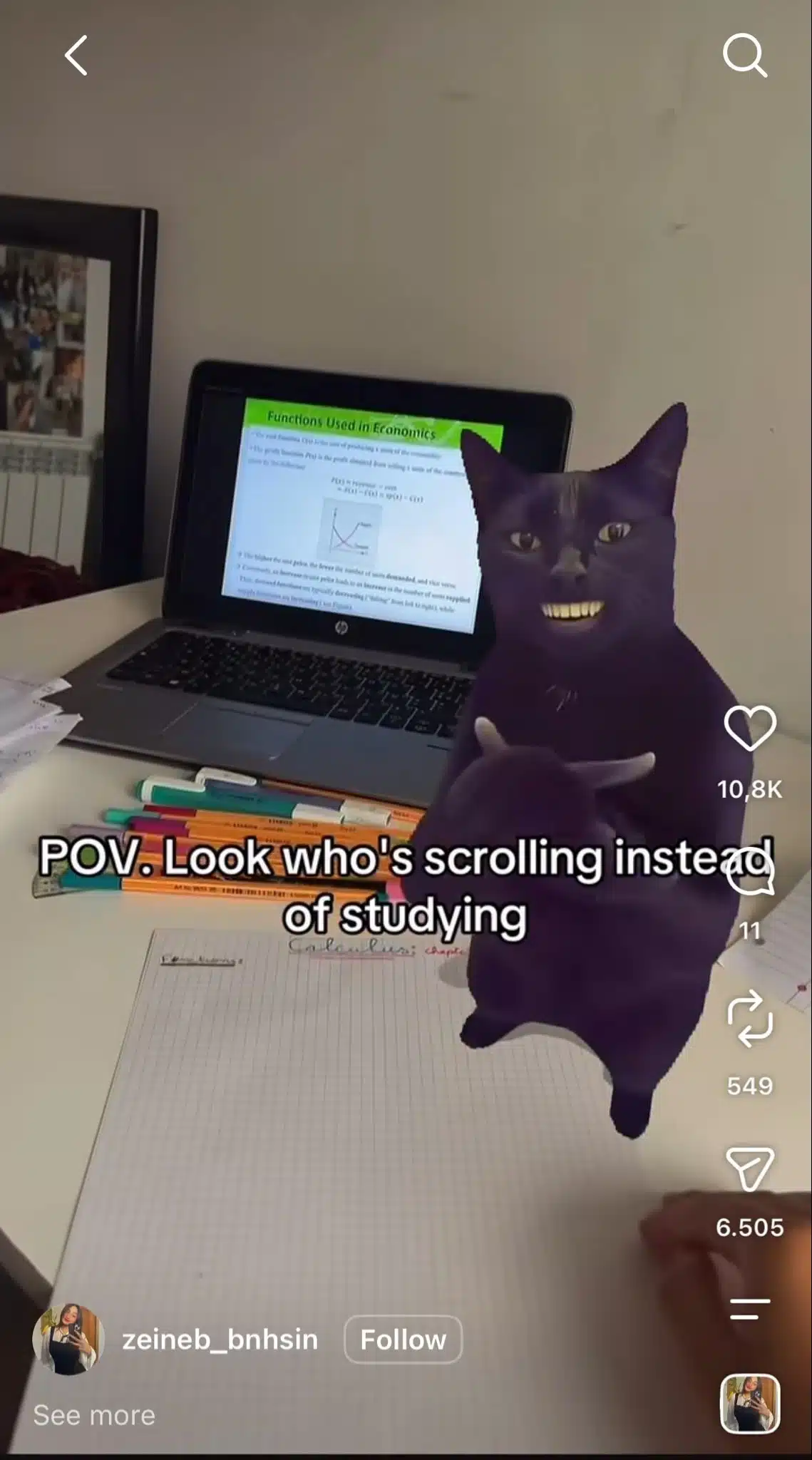 Instagram Reel from zeineb_bnhsin showing a purple cat with a human-like smile and hands in front of a study desk with a laptop, notebooks, and highlighters. Text reads, “POV. Look who's scrolling instead of studying.”